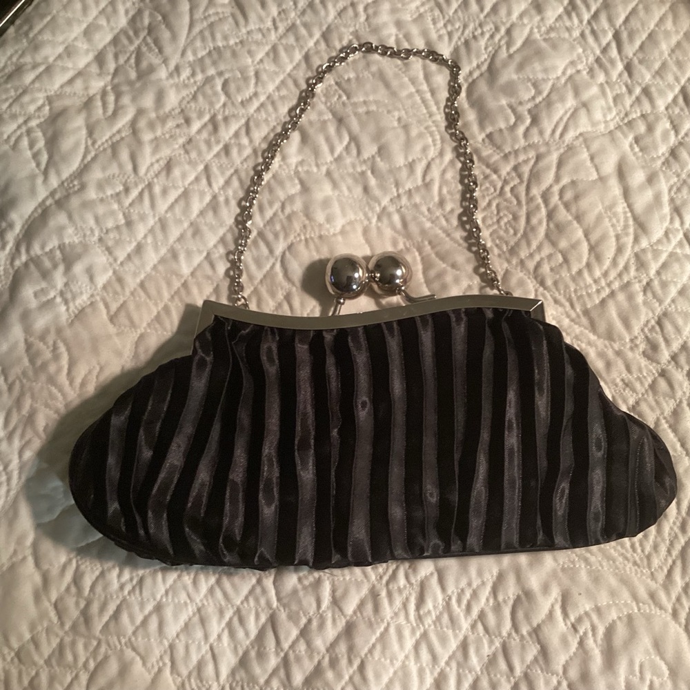 Cute black evening bag measures 11 long and five high with silver accents.